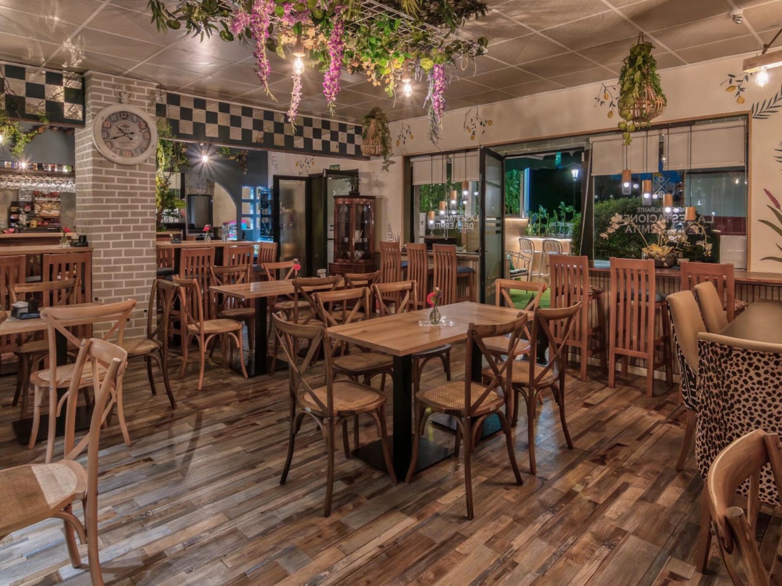 Las Estaciones de la Ermita: dining room with wooden chairs, plank flooring and hanging plants, a Nina’s Interior Design project