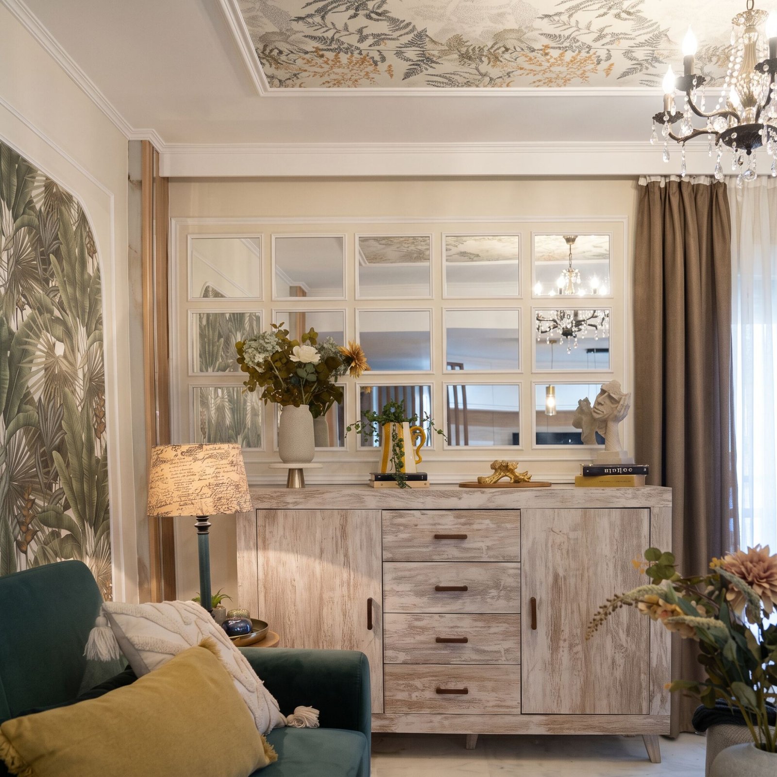Apartamento San Roque: whitewashed wood sideboard under a paned mirror, with a botanical wallpaper ceiling and a chandelier