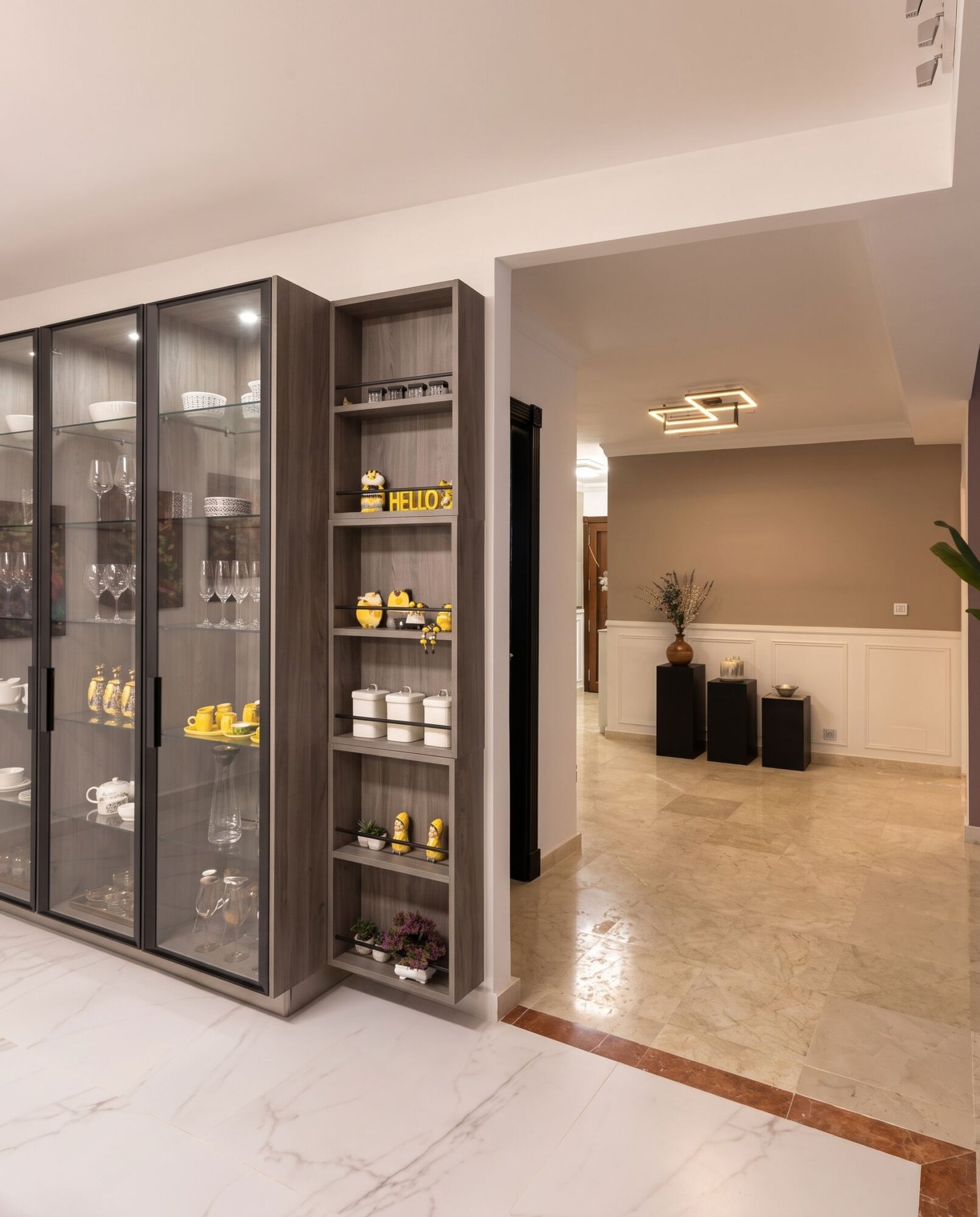 San Roque Club: vitrina de madera y cristal junto al paso al salón, proyecto de Nina’s Interior Design
