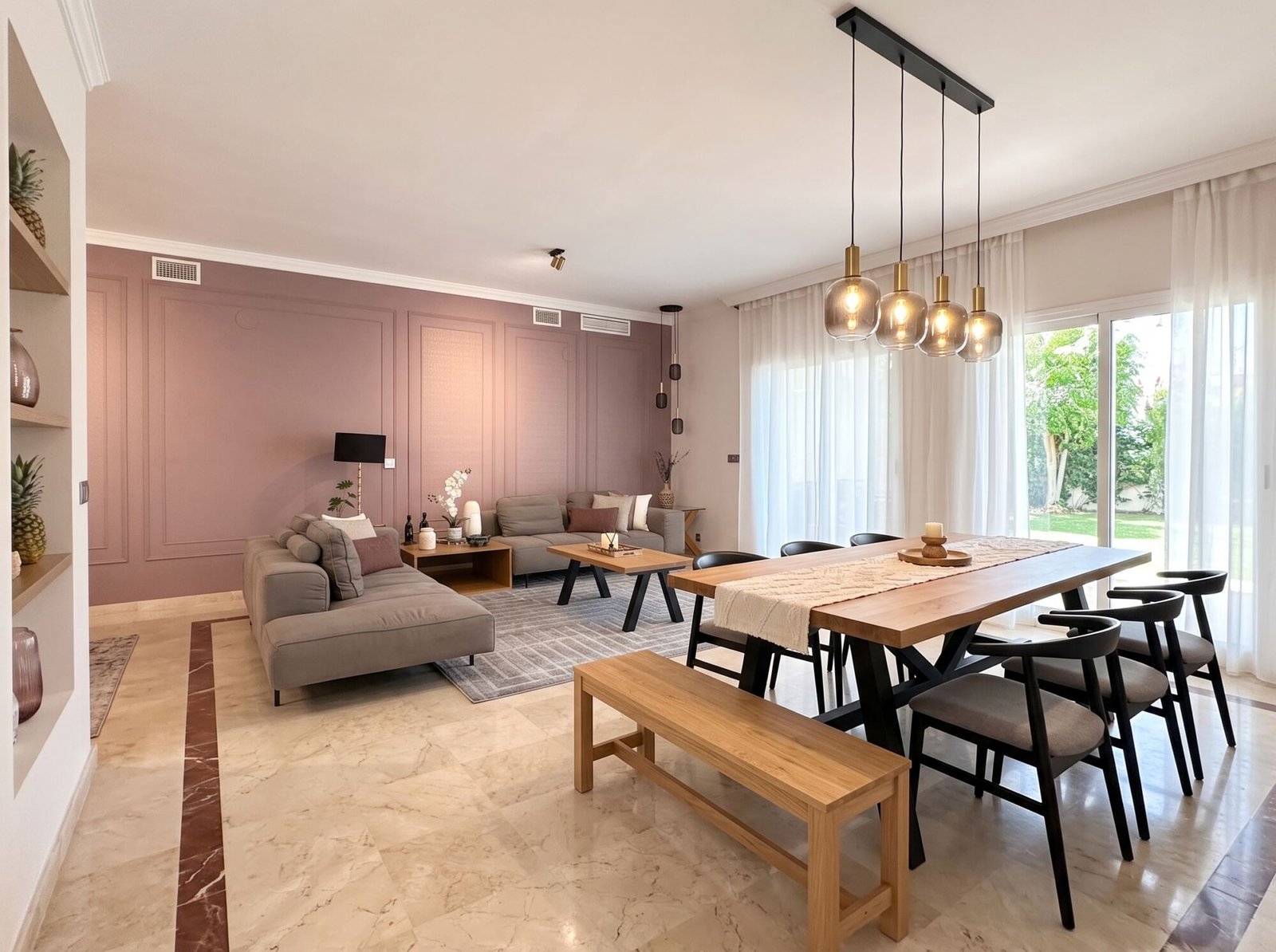 San Roque Club: living and dining room with a dusty pink wall, a wooden table and pendant lights, a Nina’s Interior Design project